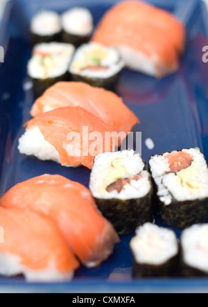 Different types of salmon sushi on a blue rectangular plate. Stock Photo