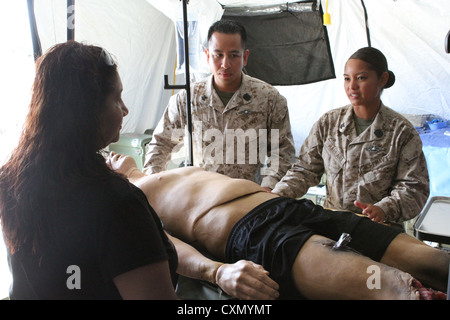 Petty Officer 2nd Class Anthony Chow and Petty Officer 2nd Class Tara Mallari, corpsmen serving with 1st Medical Battalion, instruct how to properly treat casualties of a natural disaster during San Francisco Fleet Week Oct. 3, 2012. Fleet Week is dedicated to showing civilians the United States military's capability of humanitarian assistance and disaster response preparedness on the home front. Stock Photo