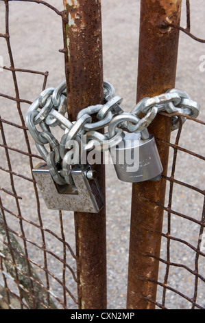 Rusty metal gates locked with padlocks and heavy chain Stock Photo