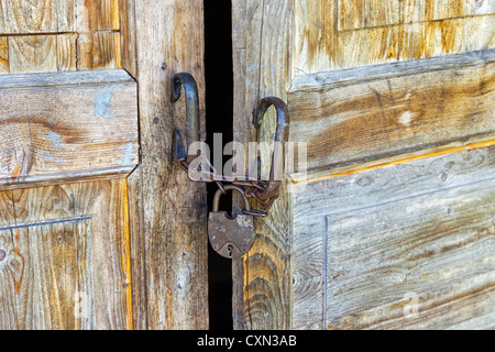 Rusty padlock on an old wooden door Stock Photo