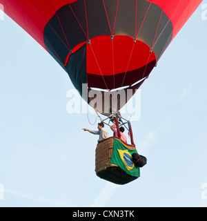 Hot air balloon floating away with Brazilian flag. Bristol International Balloon Fiesta Stock Photo