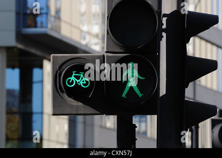 Green man pedestrian and cycle crossing signal at traffic lights in the UK Stock Photo