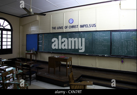 It's a photo of a Christian School Classroom in Philippines. We can see a Chalkboard with old style wood seats and furniture. Stock Photo