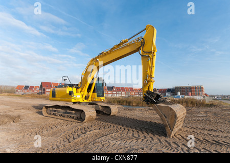 excavator in front of a newly build residential area Stock Photo