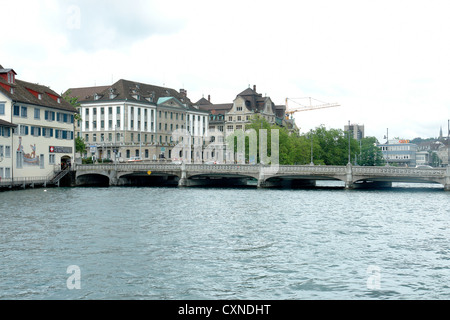 Wide and low bridge over the river Limmat in Zurich. It was bounded by magnificent buildings at both ends and was pretty busy. Stock Photo