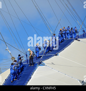 Up At The O2, people kitted out in blue overalls walking on roof of the o2 arena, sometimes referred to as the Skywalk