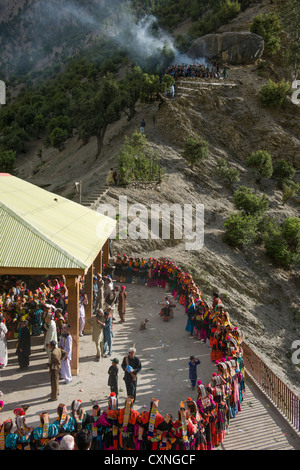 Kalash women and girls dancing at the Grum Village Charso (dancing ground), with the men's sacred area behind, Kalash Joshi (Spring Festival), Rumbur Valley, Chitral, Khyber-Pakhtunkhwa, Pakistan Stock Photo