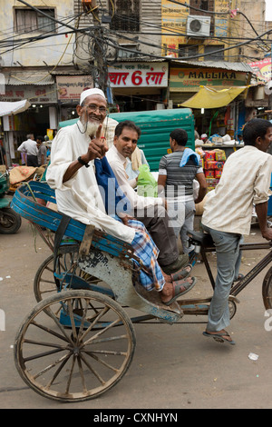 Smiling old man with white beard in a cycle rickshaw on Khari Baoli Road, (Spice Market Bazaar off Chandni Chowk), Old Delhi, India Stock Photo