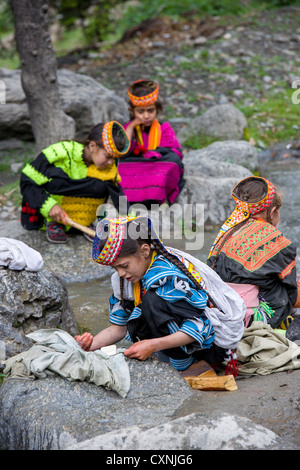 Kalash girls washing clothes in the stream running through the village of Balanguru, Rumbur Valley, Chitral, Khyber-Pakhtunkhwa, Pakistan Stock Photo