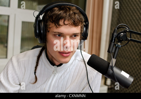 Portrait of male dj working in front of a microphone on the radio Stock Photo