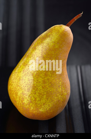 Shapely Bosc pear fruit on a black plate Stock Photo