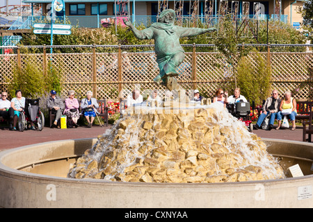 People on holiday sitting around the Jolly Fisherman sculpture in Skegness, Lincolnshire, England, UK Stock Photo