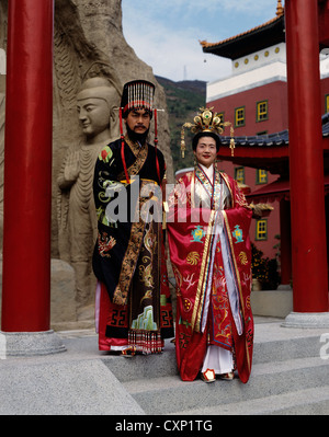 Hong Kong. Middle Kingdom. Two Chinese people in traditional Sing Dynasty clothes. Man and woman posing on temple garden steps. Stock Photo