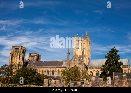 A Hercules military transport plane flies high over Wells city cathedral. Somerset. Stock Photo