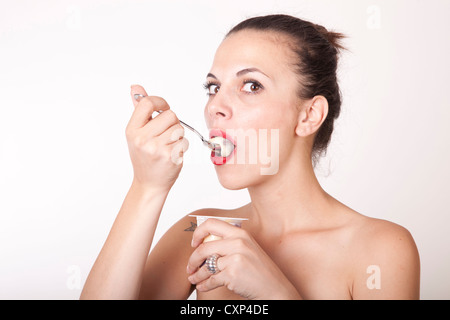 Portrait of a young beautiful woman eating pudding. Stock Photo