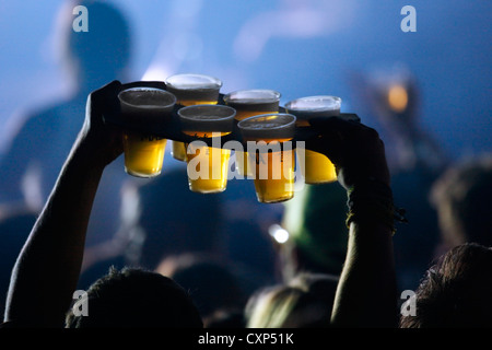 Ambiance during live rock concert and man bringing pints of beer in plastic cups to friends among spectators / crowd, Belgium Stock Photo
