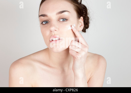 Woman applying face cream Stock Photo