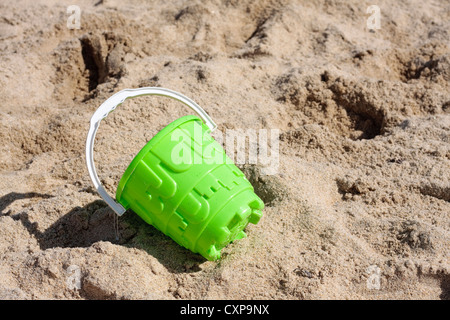 Empty green bucket on beach Stock Photo