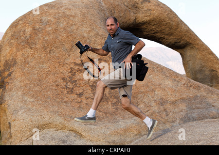 Photographer jumping past the Alabama Hills Arch, Lone Pine, California, United States of America Stock Photo