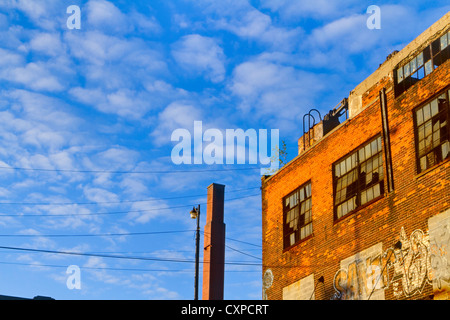 Exterior of an abandoned factory that has broken out windows and graffiti on it's walls. Stock Photo