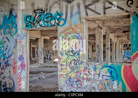 Graffiti on the interior of an abandoned factory in Detroit Michigan. The artists have been busy decorating the walls. Stock Photo