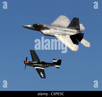 A vintage P-51 Mustang fighter aircraft and a US Air Force F-22 Raptor fighter aircraft perform a heritage flight during the National Championship Air Races at Stead Airport September 14, 2012 in Reno, Nevada. Stock Photo