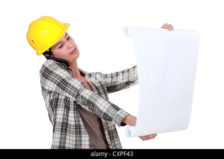 craftswoman looking at a blueprint Stock Photo - Alamy