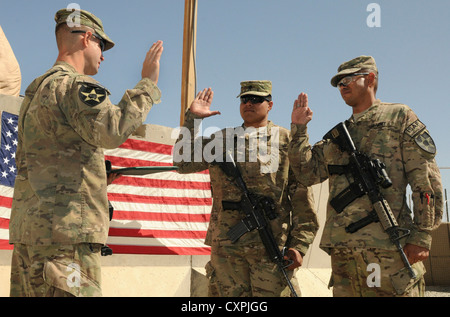 From right, Staff Sgt. Josuel Cruz, of Orlando, Fla., and Spc. Joseph Tauiliili, from the village of Vailoa, American Samoa, reenlist in the Army during a ceremony at Forward Operating Base Spin Boldak, Afghanistan, Oct. 7, 2012. The soldiers are with the 2nd Infantry Division's 5th Battalion, 20th Infantry Regiment. The 5-20th Infantry is part of the 3rd Stryker Brigade Combat Team from Joint Base Lewis-McChord, Wash. Stock Photo