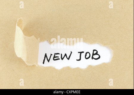 Torn paper with new job words behind it Stock Photo
