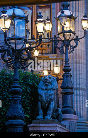 Guanajuato's Teatro Juarez wrought iron lamp posts and lion statue in evening Stock Photo