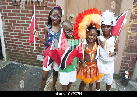 USA: Brooklyn, NY. Costumed children carrying the flags of Trinidad and Tobago await the start of The Caribbean Kiddies Parade. Stock Photo