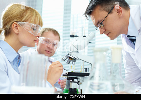 Group of clinicians experimenting with new biological material in laboratory Stock Photo