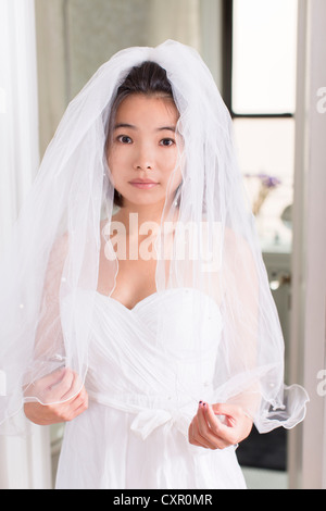 Young woman wearing wedding dress with veil