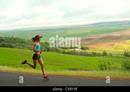 Young woman running in landscape of Palouse Hills, Washington, USA Stock Photo