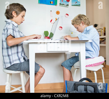 Brothers doing their homework in kitchen Stock Photo