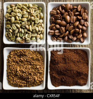 green, roasted, ground and instant coffee in ceramic bowls Stock Photo