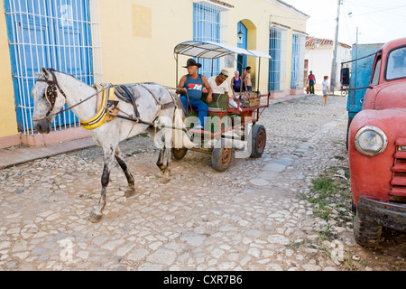 A horse cart and an old red truck in the historic district, Trinidad, Cuba, Central America Stock Photo