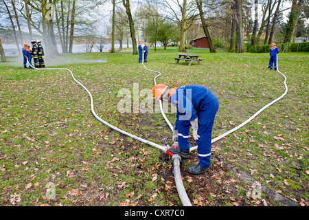 Volunteer fire brigade of Gatow, young firefighters during a firedrill on the banks of the Havel River, setup of a suction pipe Stock Photo