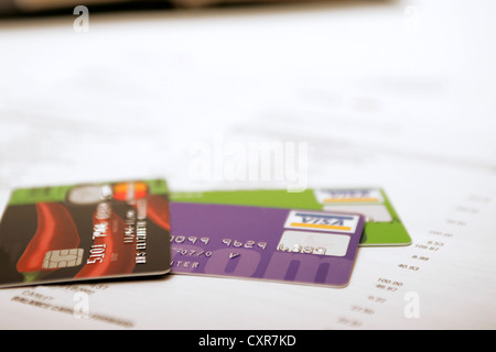 Credit debit visa cards on bank statement long list of purchases Stock Photo