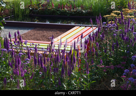 modern colourful garden bench flower border water Stock Photo