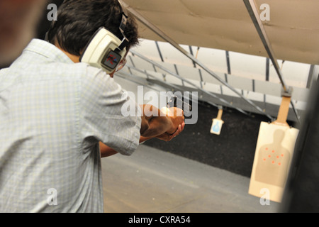 Male shooter aiming handgun during targeting practice at firing range, Colorado, USA Stock Photo
