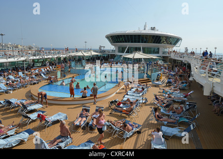 Crowded pool deck on Royal Caribbean 'Grandeur of the Seas' cruise ship, Chora, Mykonos, Cyclades, South Aegean Region, Greece Stock Photo