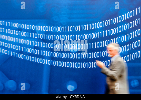 Man walking past a wall with binary numbers, binary code, the numbers zero and one, CeBIT international computer expo, Hannover Stock Photo