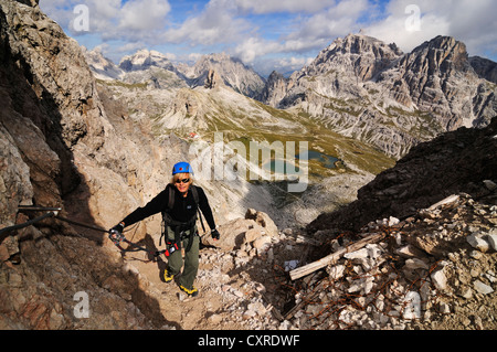 Teenager climbing on the Paternkofel fixed rope route, Boedenseen lakes, Hochpustertal valley, Dolomites Stock Photo