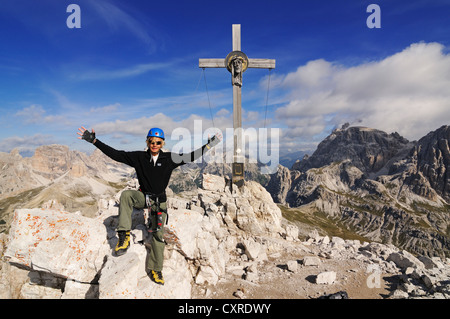 Teenager climbing on the Paternkofel fixed rope route, here standing on the summit of Paternkofel mountain Stock Photo