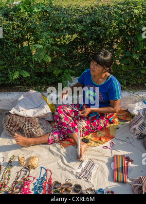 An indigenous woman sells her weavings and handicrafts on the street in Asunción, Paraguay. Stock Photo