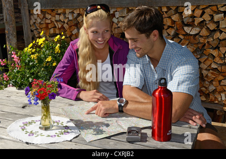 Hiking couple taking a break at Blinzalm, Hartkaiser, Wilder Kaiser Mountains, Tyrol, Austria, Europe Stock Photo