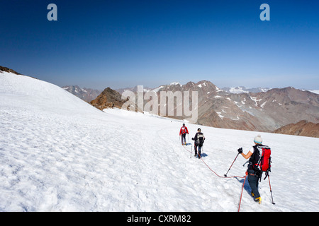 Hikers descending from Similaun Mountain on the Niederjochferner Glacier in Senales Valley, looking towards Finailspitz Mountain Stock Photo