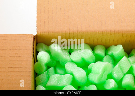 A cardboard box with green packing styrofoam peanuts Stock Photo