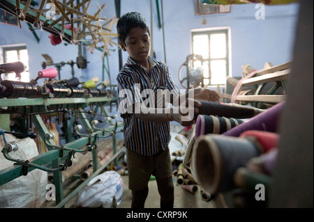 Child labourer, 11 years, operating machinery in a mosquito net factory, Karur, Tamil Nadu, South India, India, Asia Stock Photo